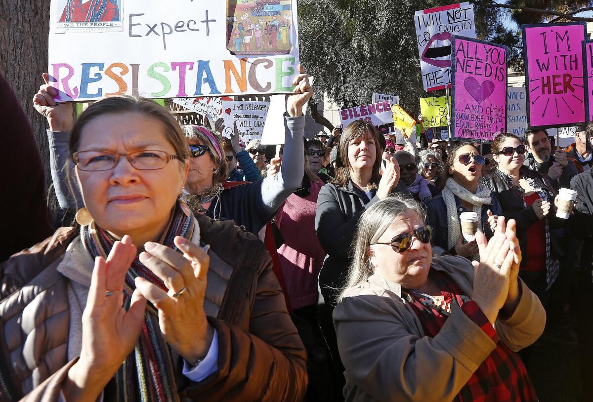 Demonstrators applaud speakers in support of the Women's March on Washington at the Arizona Capitol.