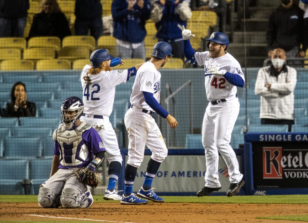 Dodgers second baseman Max Muncy celebrates with teammates Justin Turner and Chris Taylor.