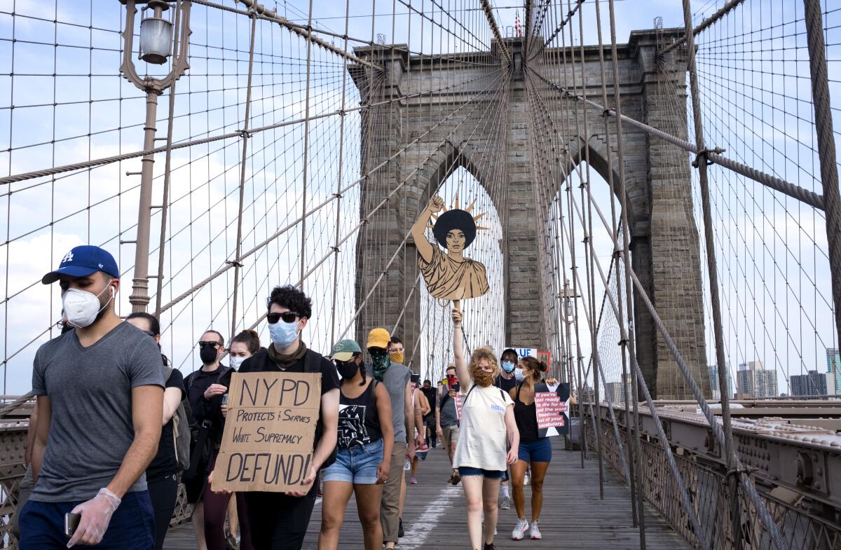 Protesters and activists walk across the Brooklyn Bridge June 6, 2020, in New York. 