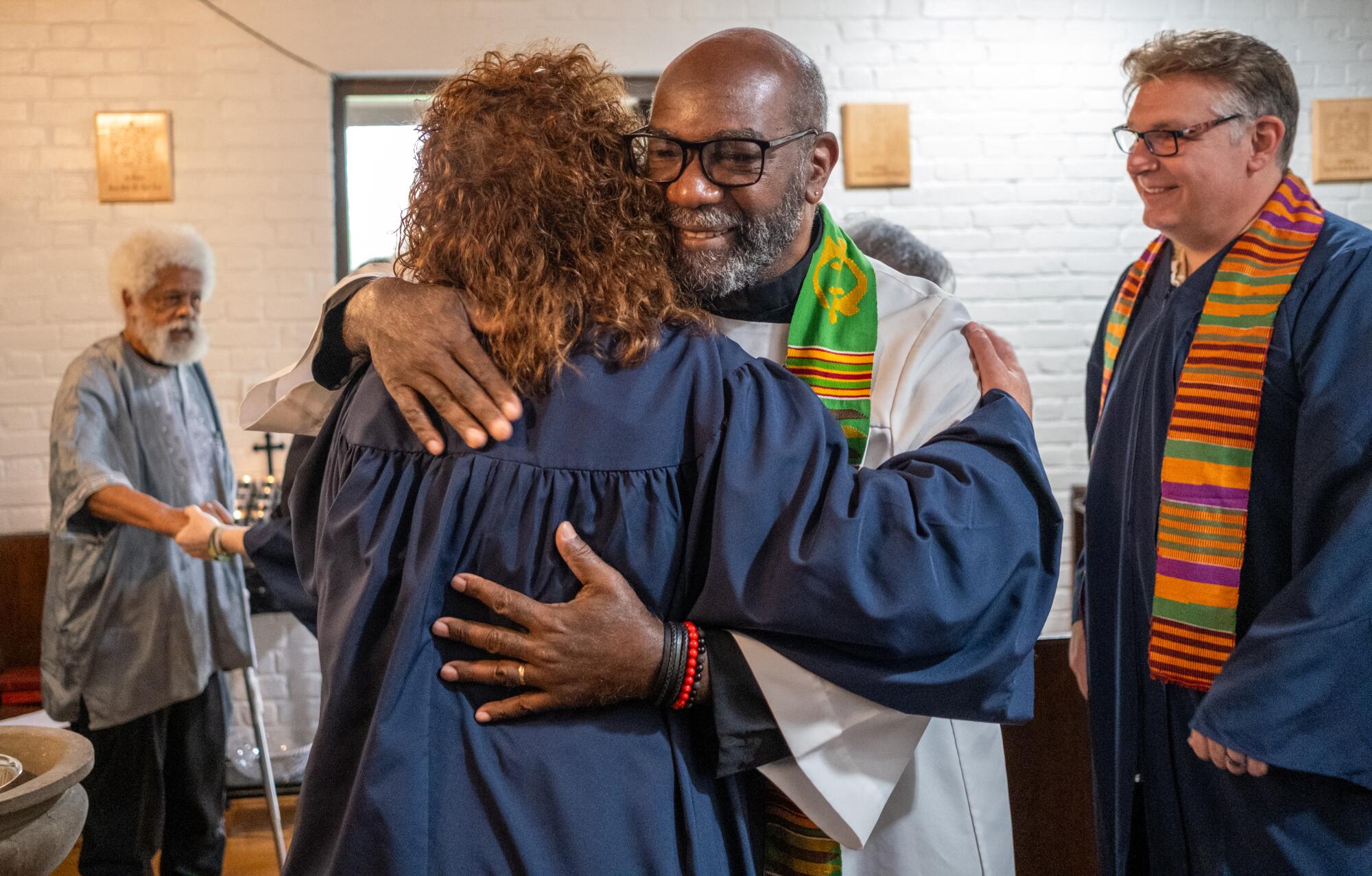 Robert Edwards, middle facing camera, hugs Sarah Moore after services at the church in May. 