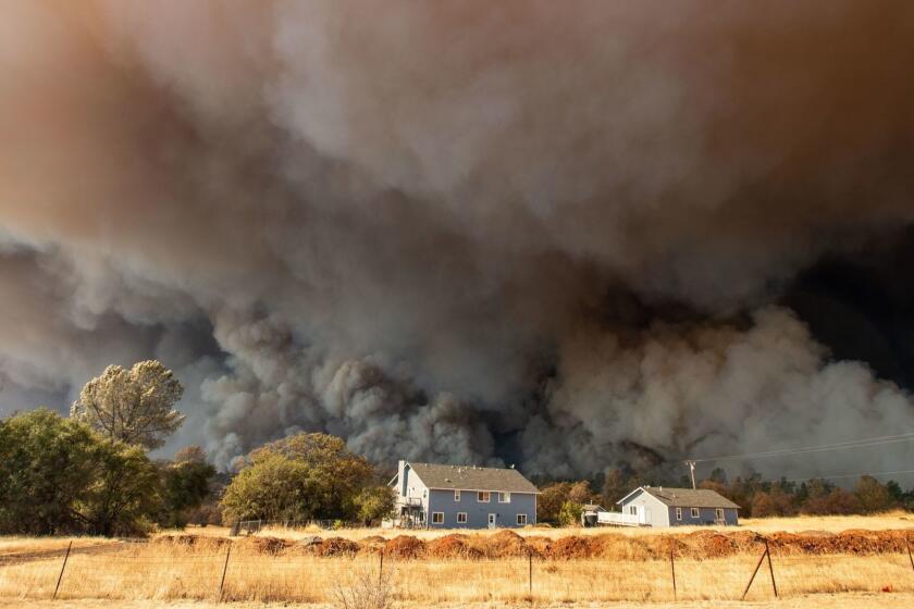 (FILES) In this file photo taken on November 8, 2018 a home is overshadowed by towering smoke plumes as the Camp fire races through town in Paradise, California. - California utility PG&E, facing billions of dollars in potential liabilities over its role in a series of deadly wildfires, filed for bankruptcy protection on January 29, 2019. The company, the largest utility in America's most populous state, has been under intensifying scrutiny in the wake of the so-called 2018 Camp Fire in Northern California that left 86 people dead, destroyed some 18,000 buildings and came on the heels of deadly wildfires in the state in 2017.That Camp Fire catastrophe, the deadliest fire in the state's modern history, has sharpened questions about whether a company with a troubled history has put profit ahead of safety. (Photo by Josh Edelson / AFP)JOSH EDELSON/AFP/Getty Images ** OUTS - ELSENT, FPG, CM - OUTS * NM, PH, VA if sourced by CT, LA or MoD **