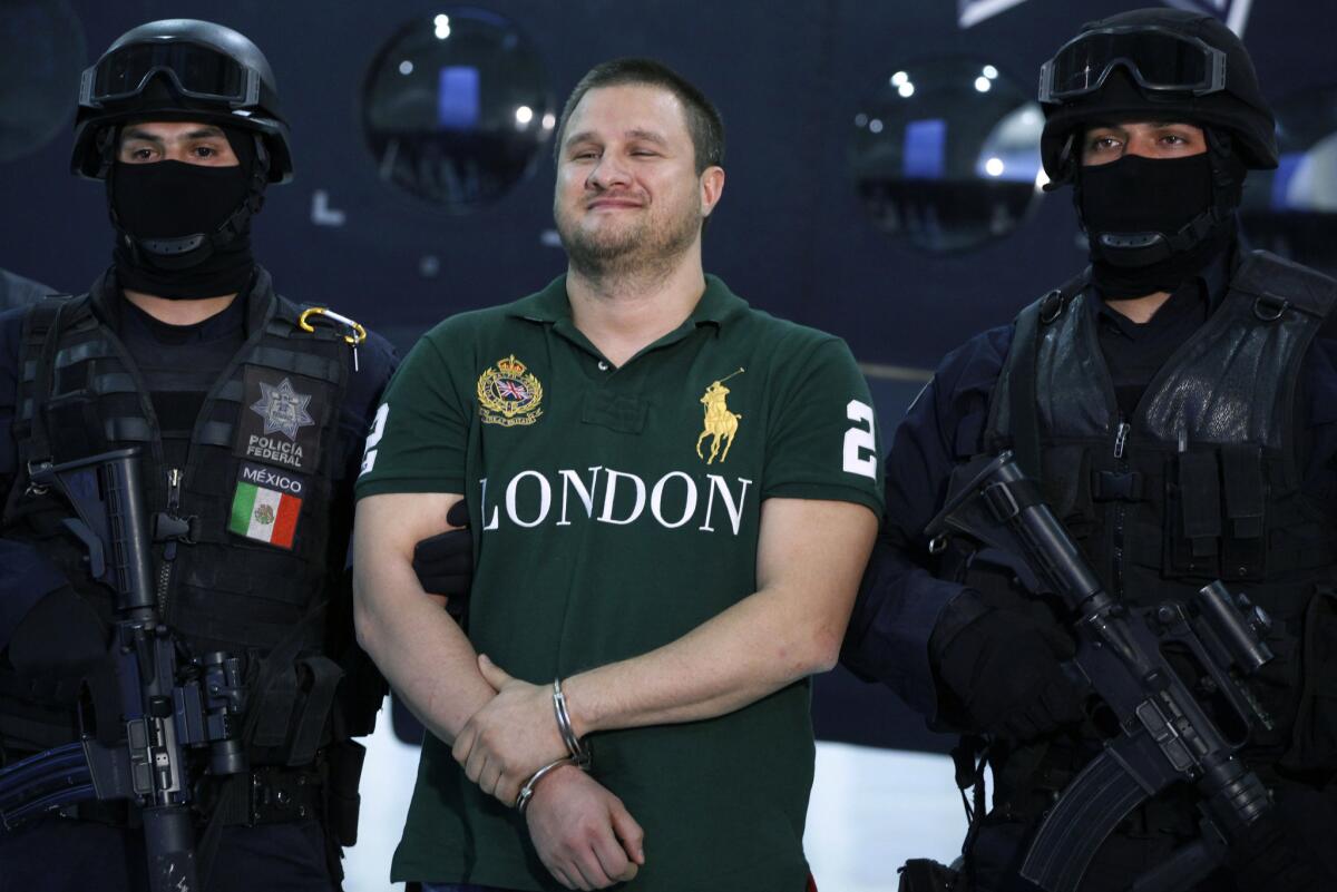 Mexican federal police escort Texas-born suspect Edgar Valdez Villarreal, alias "the Barbie," in Mexico City in 2010.