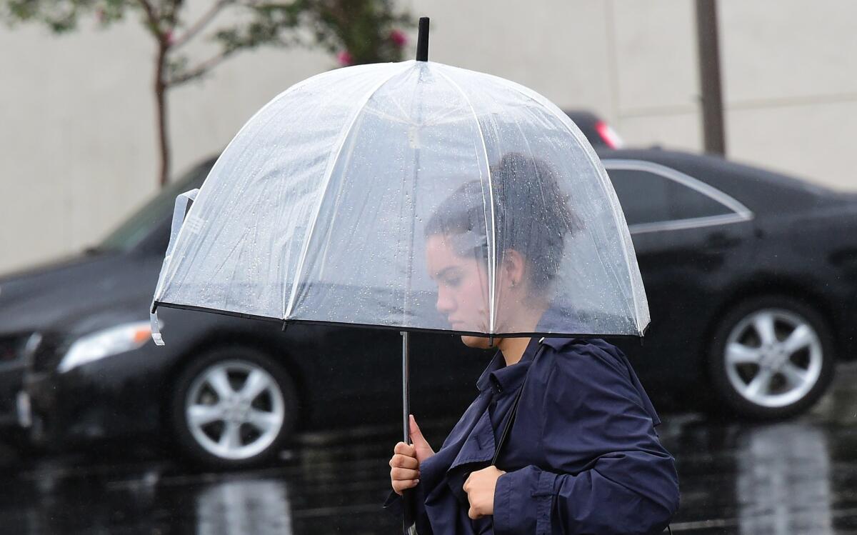 A woman walks during a steady rainfall in Los Angeles last month.
