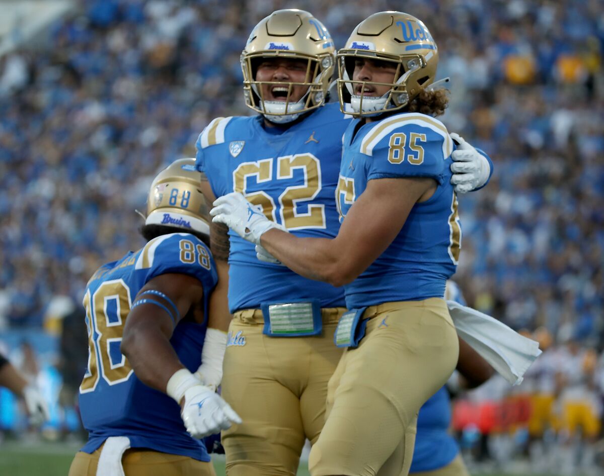 UCLA tight end Greg Dulcich (85) is congratulated by teammate Duke Clemens after scoring a touchdown against LSU.