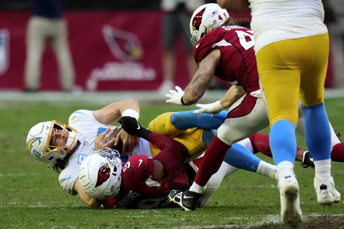 Los Angeles Chargers quarterback Justin Herbert (10) is sacked by Arizona Cardinals linebacker Isaiah Simmons during the second half of an NFL football game, Sunday, Nov. 27, 2022, in Glendale, Ariz. The Chargers defeated the Cardinals 25-24. (AP Photo/Ross D. Franklin)