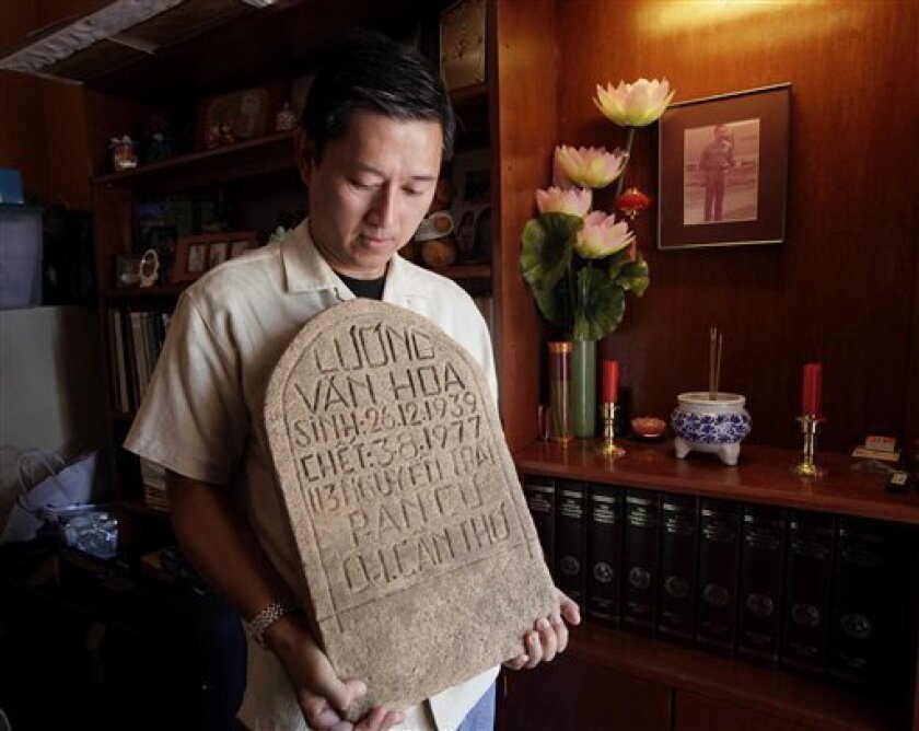 In this photo taken Friday, July 29, 2011, Daniel Luong holds the tombstone of his father, former South Vietnamese Army Capt. Luong Van Hoa, at his home in Los Angeles. Nearly a year to the day after collecting the tombstone and human remains from a grave at the former site of the Lang Da re-education camp in Vietnam in July 2010, Luong got the news that the remains were a positive DNA match for his father. He last saw his father in 1976 when he was just 12 years old. (AP Photo/Nick Ut)