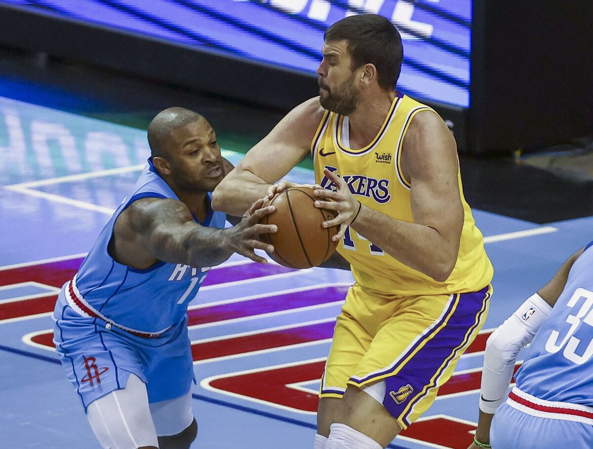Rockets forward P.J. Tucker tries to steal the ball from Lakers center Marc Gasol on Tuesday night in Houston.