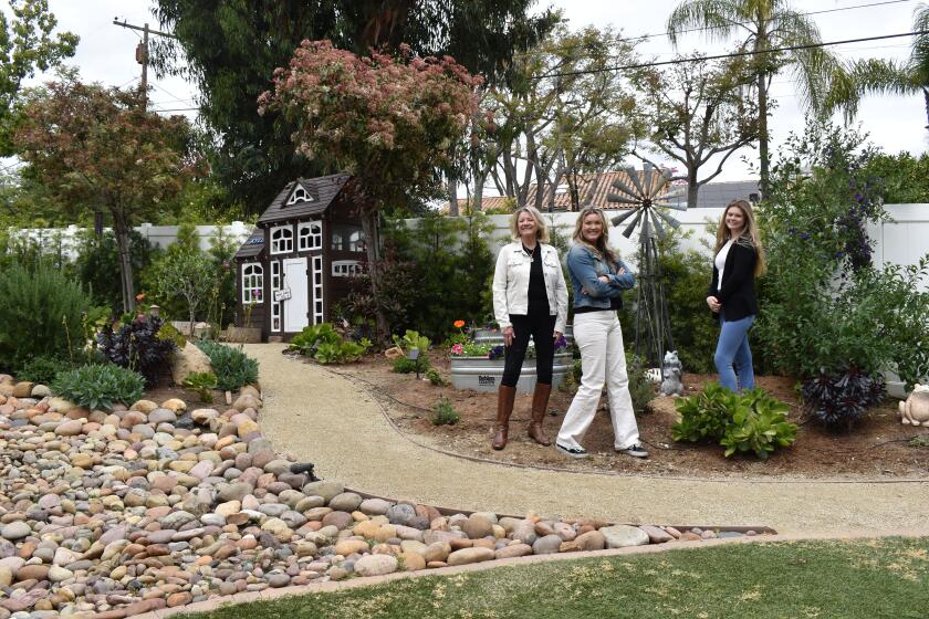 MJ Rice with Crystal and Lexie Bogan in the Bogan family’s Poway garden. In the background is the custom dog house.