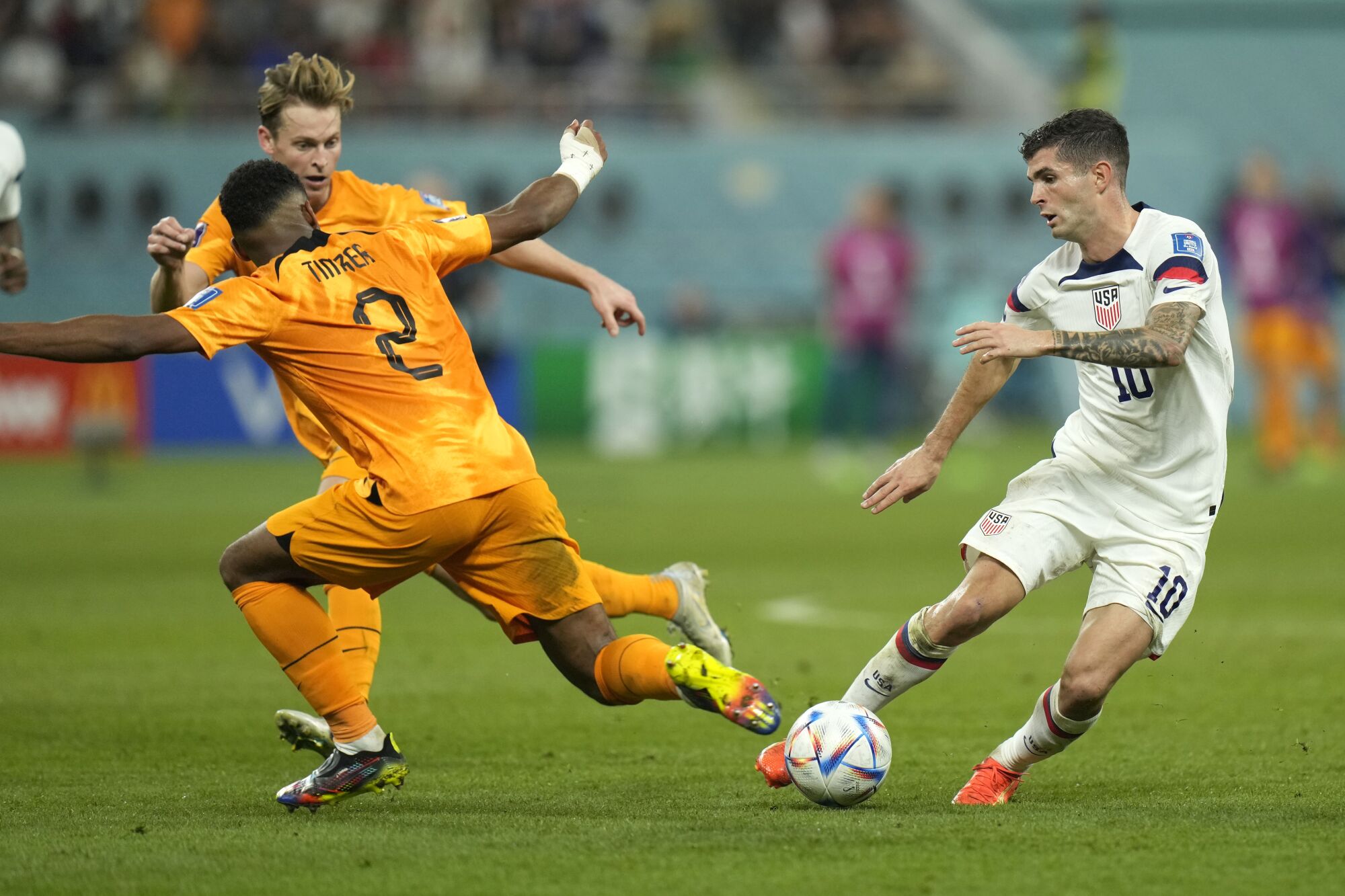 Christian Pulisic, Dünya Kupası maçında Hollandalı Jurrien Timber ve Frenkie de Jong ile top için yarışıyor. 