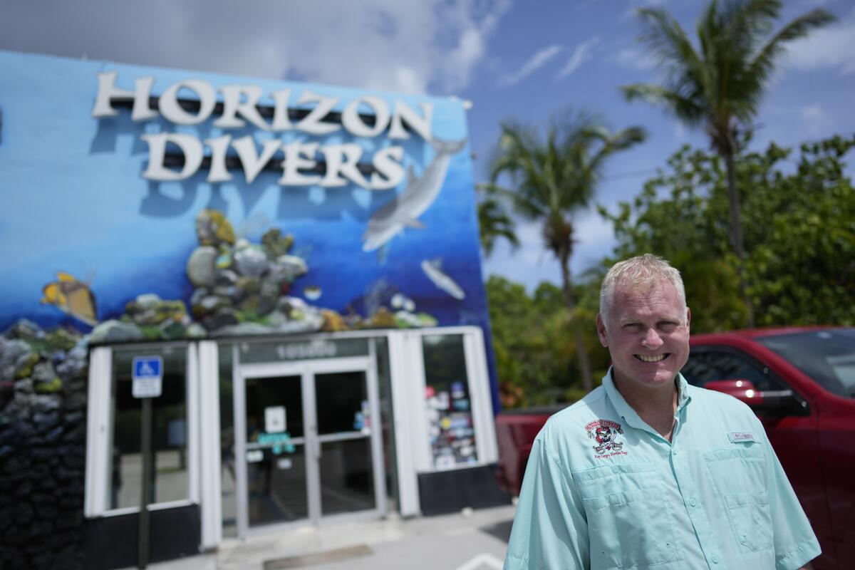 Dan Dawson, propietario de Horizon Divers, posa afuera de su tienda de buceo en Key Largo, Florida, 