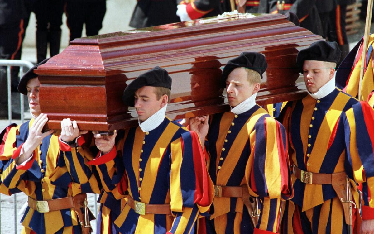 FILE - In this Saturday May 16, 1998 filer, members of the papal Swiss Guard carry the coffin of Alois Estermann, newly appointed commander of the Swiss papal guards at the Vatican, out of the St. Stephan's church in Beromuenster, Switzerland. The Vatican secretary of state has intervened personally in one of the most sensational Vatican scandals of recent times: The 1998 murder of the Swiss Guard commander and his wife, purportedly by a disgruntled younger Swiss Guardsman who then took his own life. Cardinal Pietro Parolin asked the Vatican City State tribunal to pay “particular attention” to the request by the mother of the accused guardsman, Cedric Tornay, to have access to the court files of the investigation that was officially archived in 1999. (AP Photo/TEAM, File )