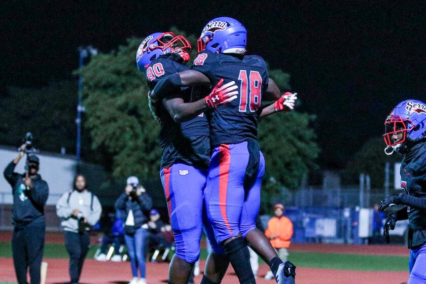 Andre Nickerson (left) and Ty Law celebrate during Gardena Serra's 38-28 win over Los Alamitos.