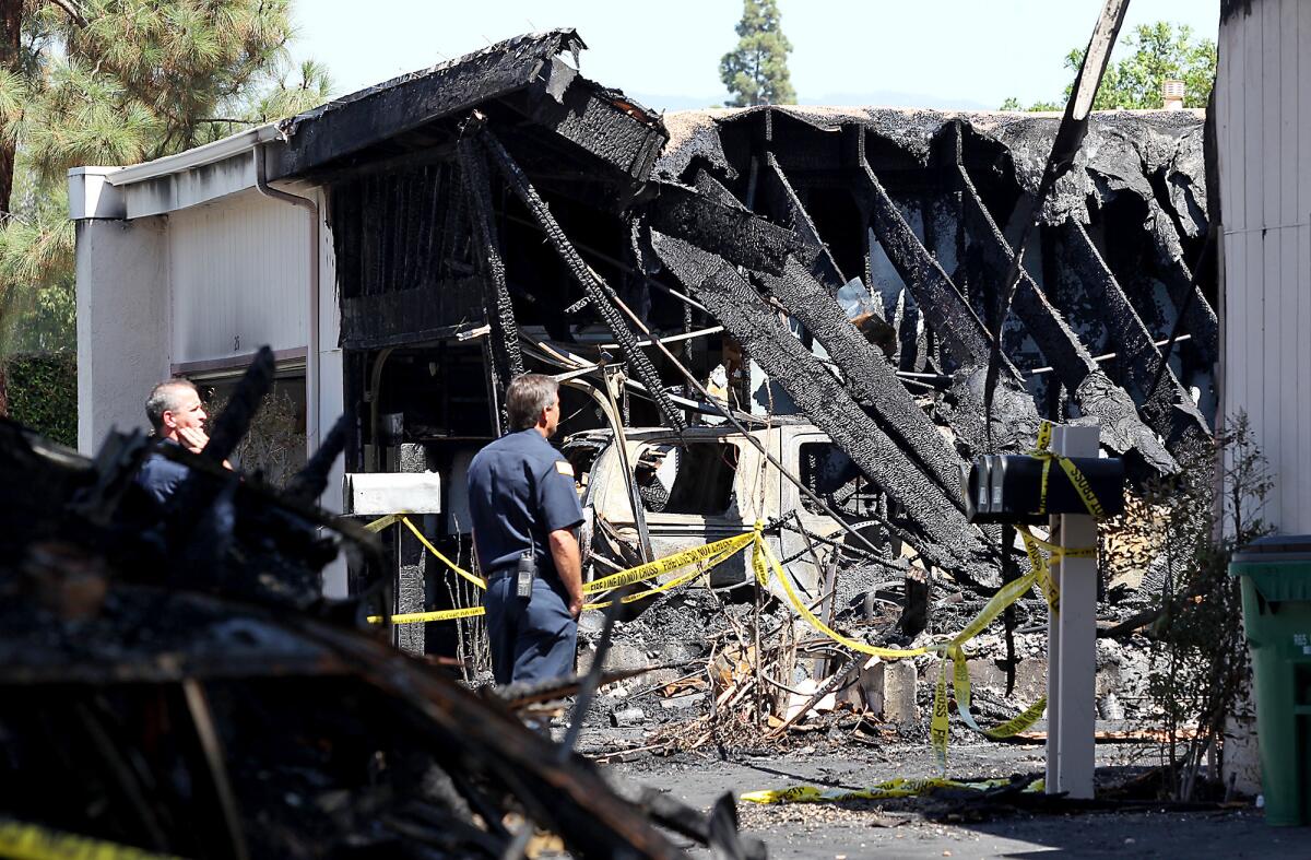 A fire that officials believe was started by a machine that uses a laser to engrave wood charred three condominiums in Irvine, displacing 15 people.