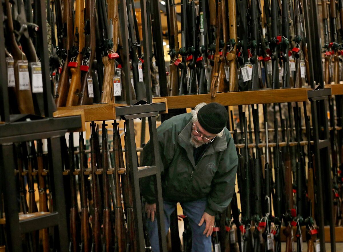 A man looks at the shotgun section of Cabela's while shopping on Black Friday in Hazelwood, Mo. 