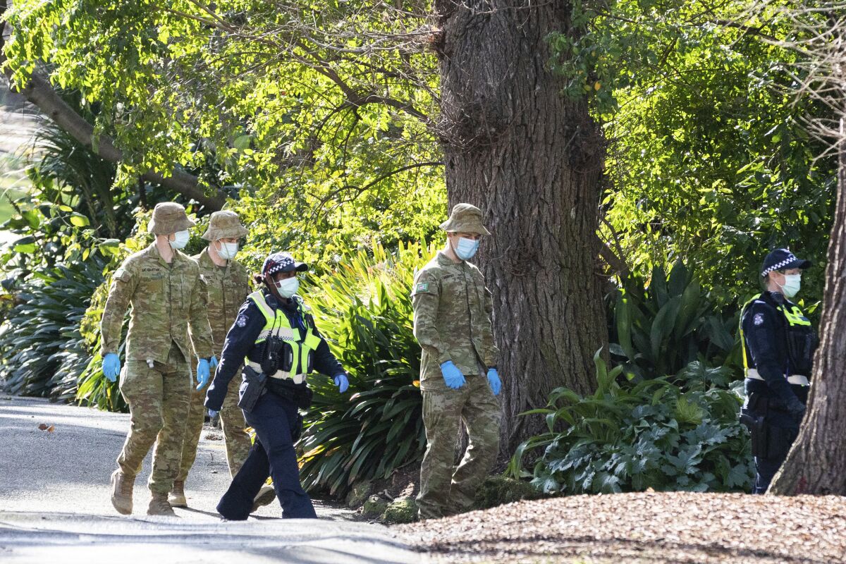 Australian Defence Force staff (ADF) and Victorian police are seen on patrol as a lockdown of Melbourne forces people to stay at home if not working due to the continuing spread of COVID-19, Wednesday, Aug. 5, 2020. Victoria state, Australia's coronavirus hot spot, announced on Monday that businesses will be closed and scaled down in a bid to curb the spread of the virus. (AP Photo/Asanka Brendon Ratnayake)