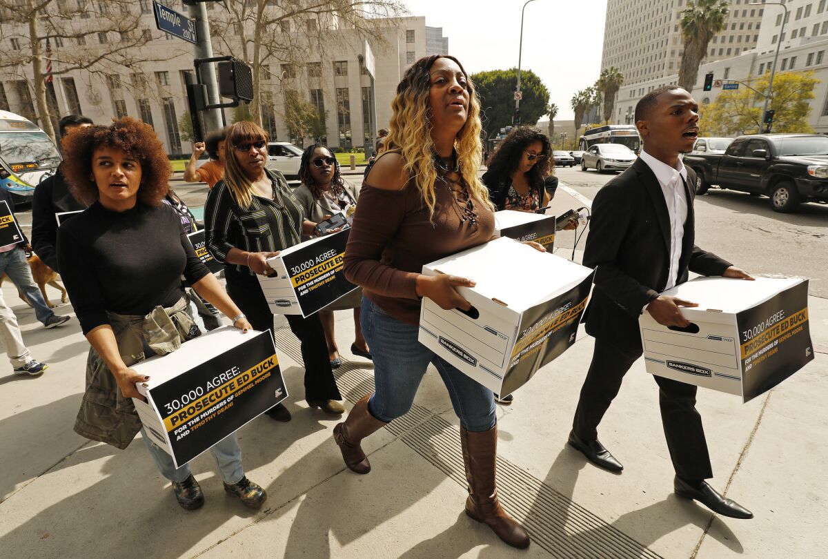 People carry boxes of petitions across a street