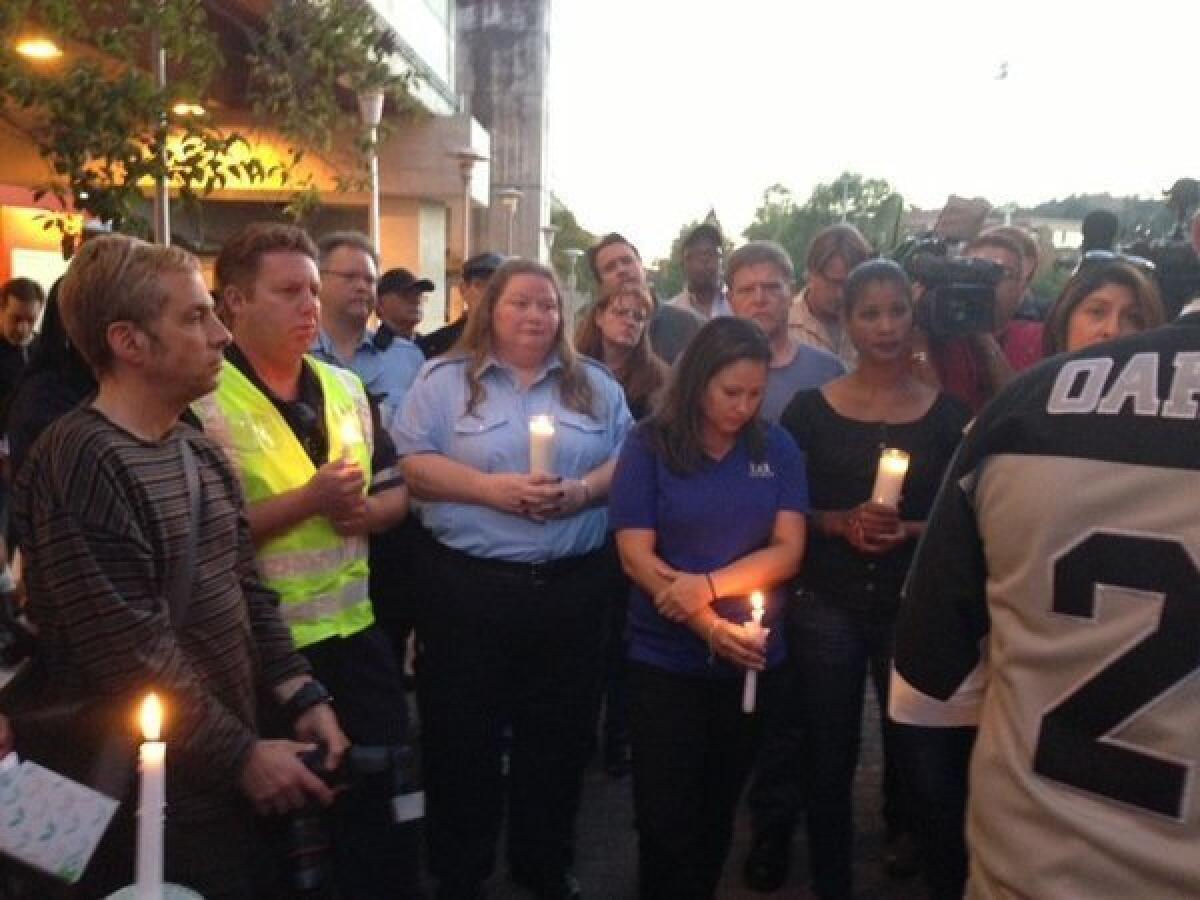 BART workers gather at a Sunday evening vigil for two employees struck and killed by a train on Saturday.