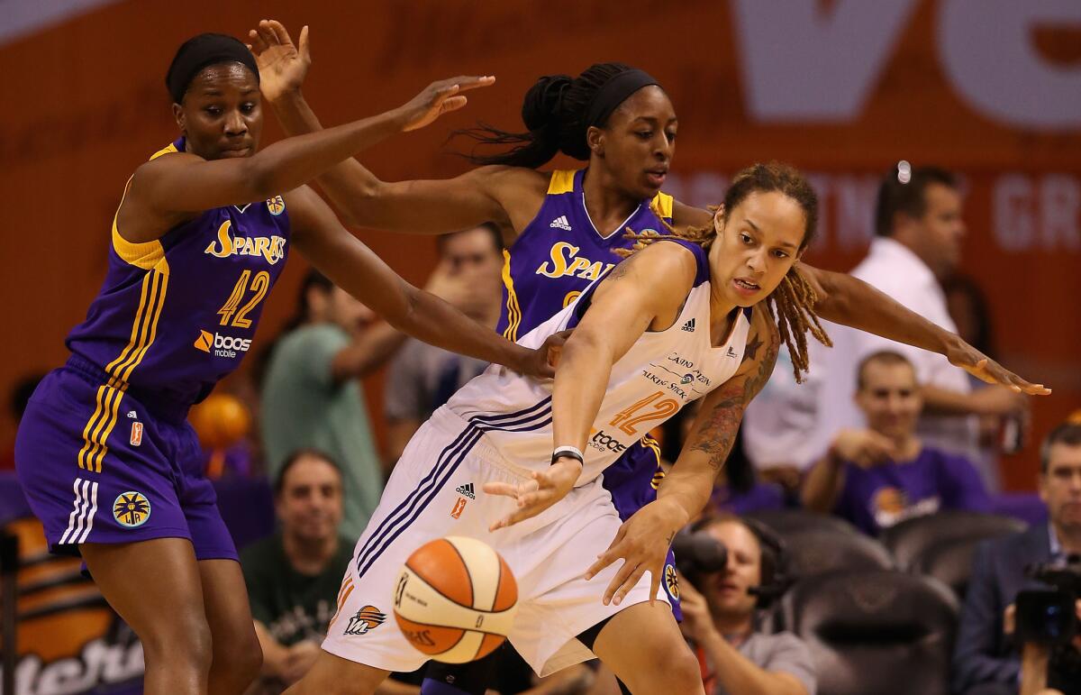 Mercury center Brittney Griner (42) passes the ball under pressure from Sparks forwards Jantel Lavender (42) and Nneka Ogwumike (30) during the first half on Aug. 16, 2014.