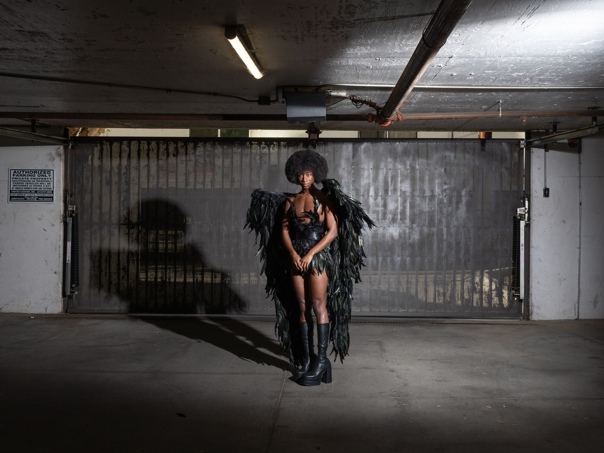 Full body photo of Tyris Winter wearing a black feather raven outfit.