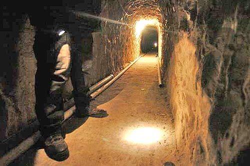 THE SHAFT: A Mexican police officer Wednesday examines a tunnel running under the U.S.-Mexico border that officials say was used by drug smugglers. The tunnel was equipped with lighting, ventilation and a pulley system.