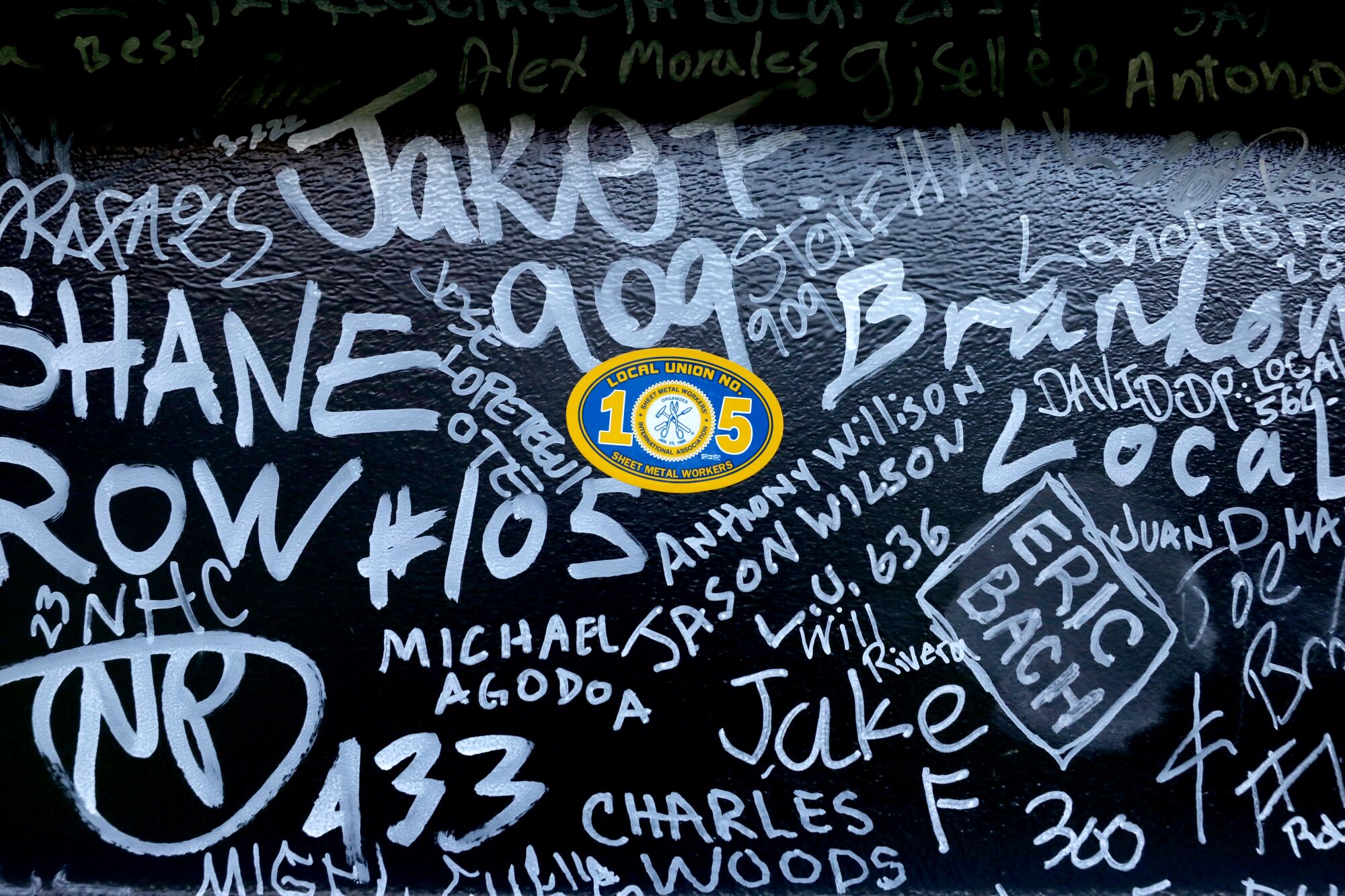 A close-up view of the signatures on a steel beam placed atop the Intuit Dome.