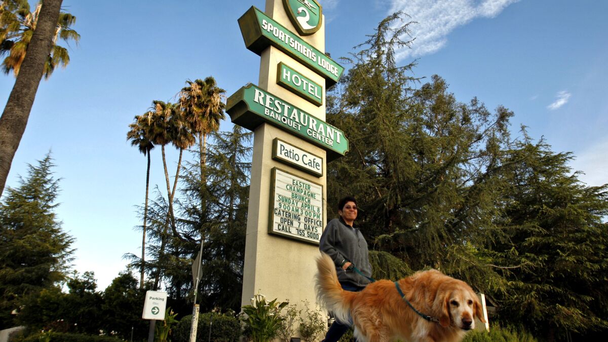 A woman walks her dog along Ventura Boulevard past the landmark Sportsmen's Lodge in Studio City. Some neighbors objected to the retail complex, fearing it will increase noise and traffic.
