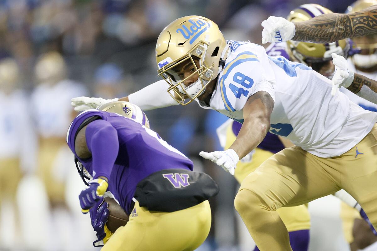 UCLA linebacker Joquarri Price, right, tackles Washington's Giles Jackson during a game in October 2021.