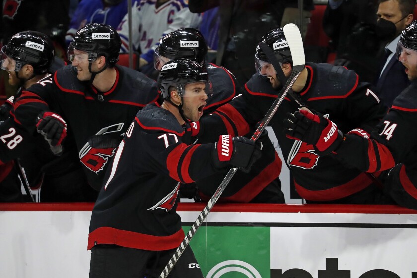Carolina Hurricanes' Tony DeAngelo (77) celebrates his goal along the bench during the third period of an NHL hockey game against the New York Rangers in Raleigh, N.C., Friday, Jan. 21, 2022. (AP Photo/Karl B DeBlaker)