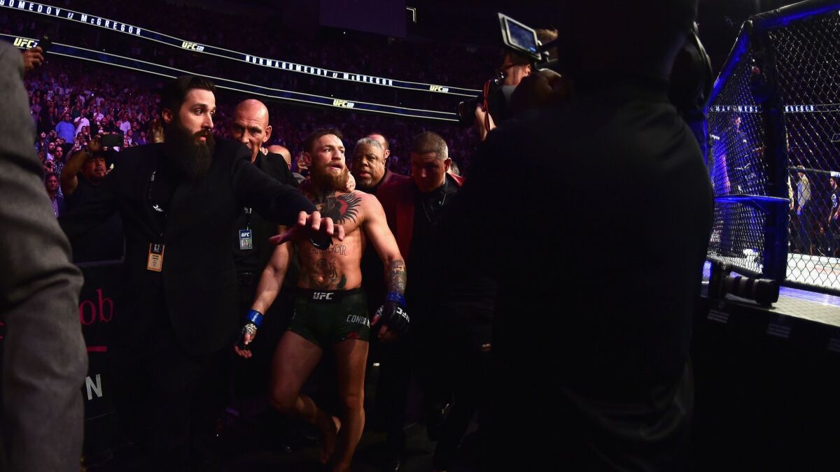 Conor McGregor of Ireland is escorted out of the octagon after being defeated by Khabib Nurmagomedov of Russia in their UFC lightweight championship bout during UFC 229.