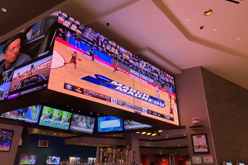 Fans watch NCAA tournament games at an Arizona sports book.