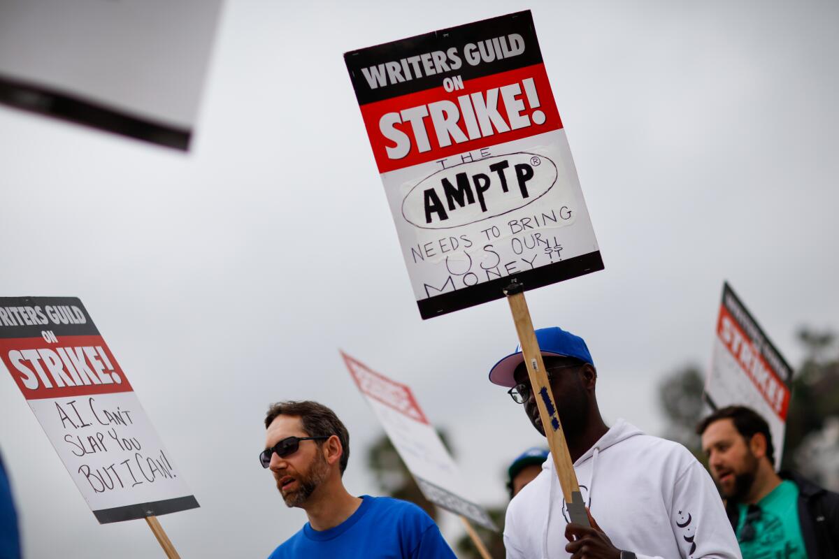 Supporters of the Writers Guild of America picket with signs