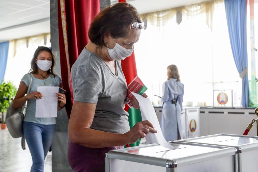 FILE - In this Aug. 9, 2020, file photo, a woman casts her ballot at a polling station during the presidential election in Minsk, Belarus, Sunday, Aug. 9, 2020. In the three weeks since the election that kept President Alexander Lukashenko in power, hundreds of thousands of people have protested what they say was a rigged outcome. (AP Photo/Sergei Grits, File)