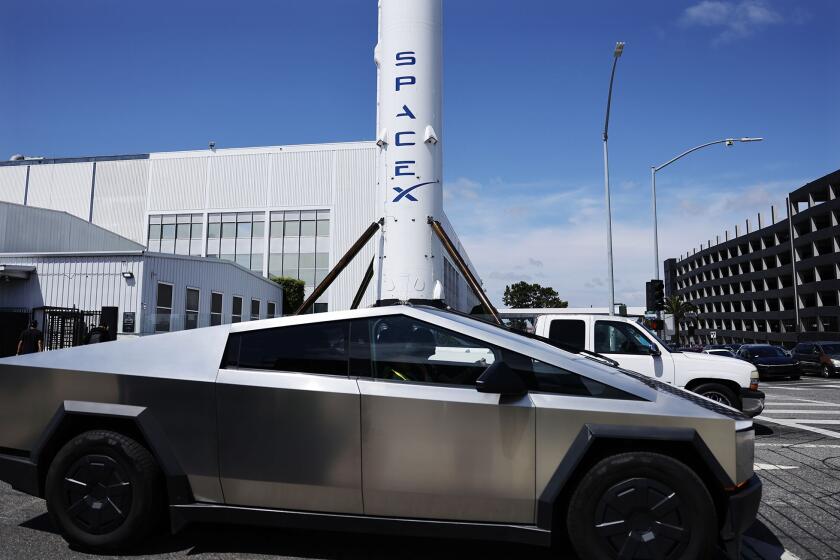A Tesla Cybertruck passes a SpaceX Falcon 9 rocket displayed at a SpaceX facility in Hawthorne, California. Photographer: Mario Tama/Getty Images