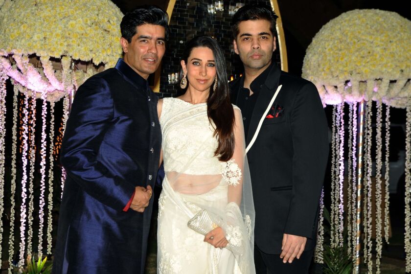 Bollywood producer Karan Johar, right, shown at a Dec. 14, 2014, wedding with actress Karishma Kapoor and designer Manish Malhotra, was one target of the ribald humor on the "Knockout" program.