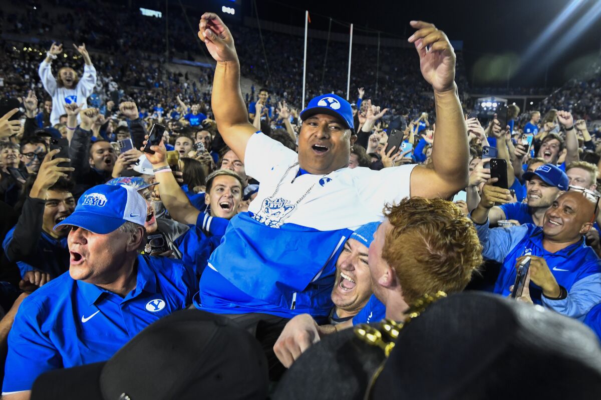 A crowd holds Brigham Young head coach Kalani Sitake after his team defeated Utah during a NCAA college football game Saturday, Sept. 11, 2021, in Provo, Utah. (AP Photo/Alex Goodlett)
