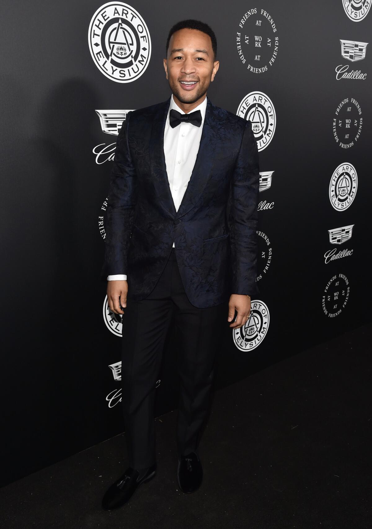 John Legend wore Ermenegildo Zegna Couture tuxedo pants paired with a subtly flashy shawl-collar jacket in a brocaded midnight blue to the Art of Elysium's gala in Santa Monica in January.