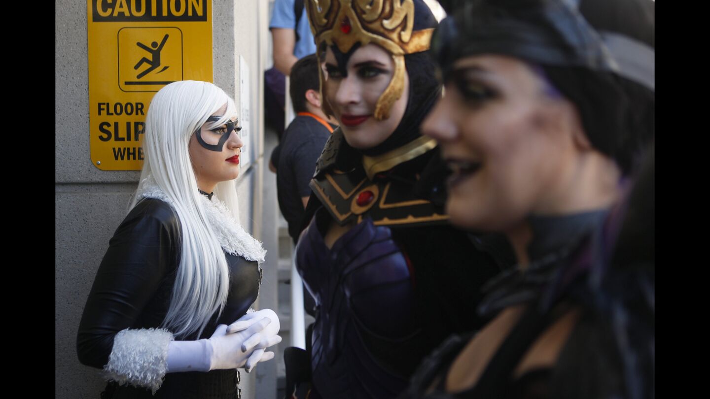 Miss M Jay, left, hangs out outside the San Diego Convention Center during the first day of the Comic-Con International convention. Jay was dressed as the Black Cat.