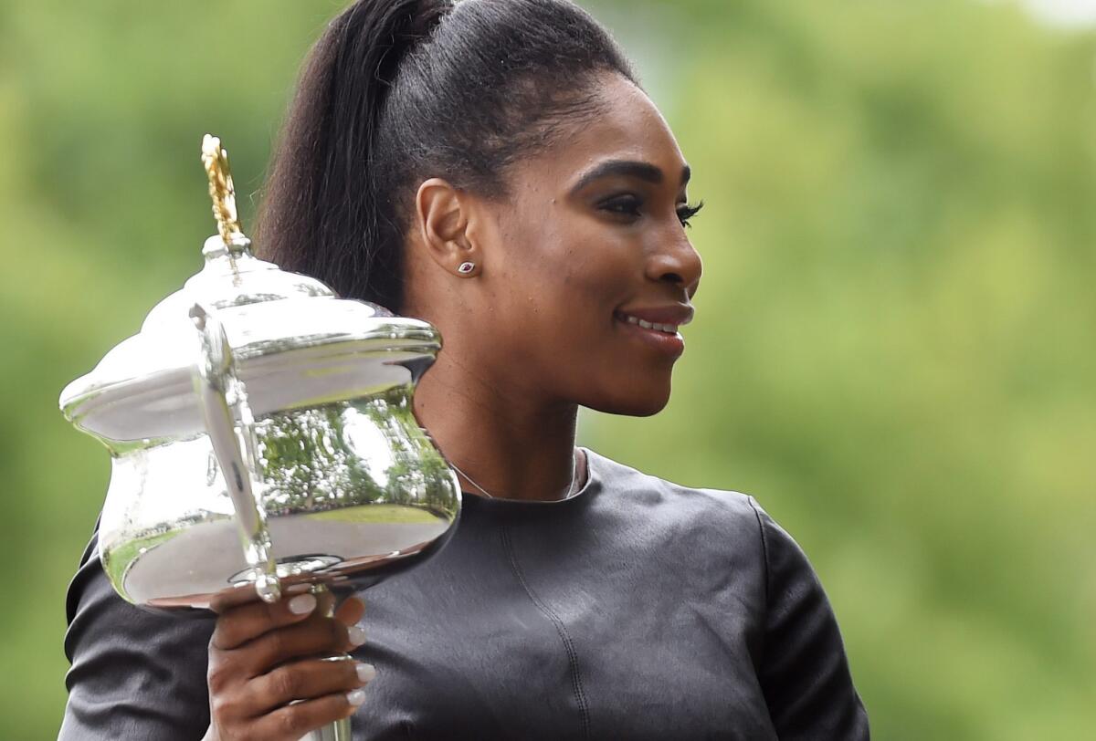 Serena Williams poses with the Daphne Akhurst Memorial Cup after defeating Maria Sharapova in the final of the Australian Open for her 19th grand slam victory.