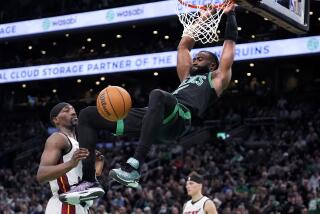 El base de los Celtics de Boston Jaylen Brown clava el balón frente al pívot del Heat de Miami Bam Adebayo en el juego 5 de la primera ronda de la postemporada el miércoles 1 de mayo del 2024. (AP Foto/Charles Krupa)