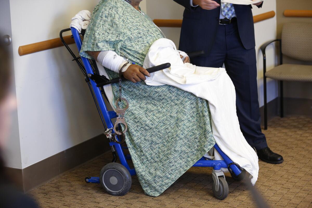 Jesse Gomez is wheeled in for his arraignment at UCSD Medical Center on Tuesday.