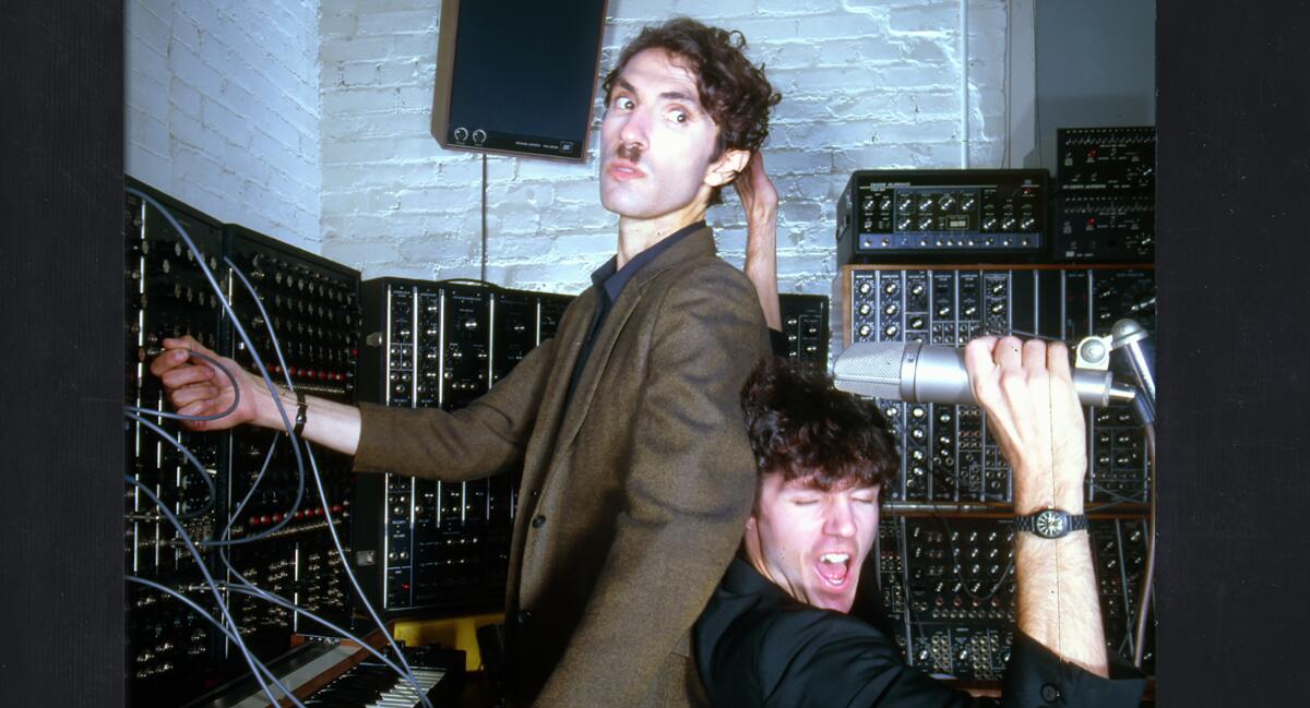 Two men pose with recording equipment.