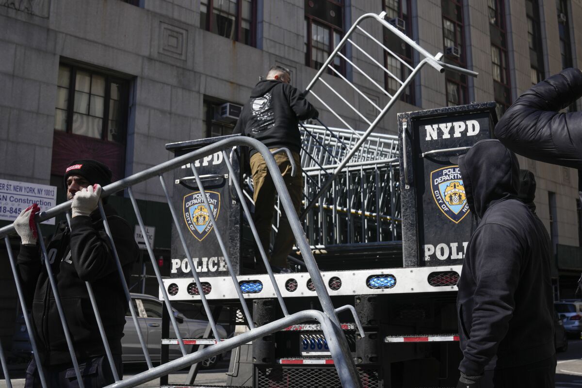 Barricades are unloaded from a truck near the courts in New York, Monday, March 20, 2023. (AP Photo/Seth Wenig)