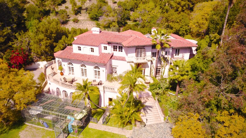 An aerial view of the multi-level home, its balconies, glassed-in patio and surrounding trees.