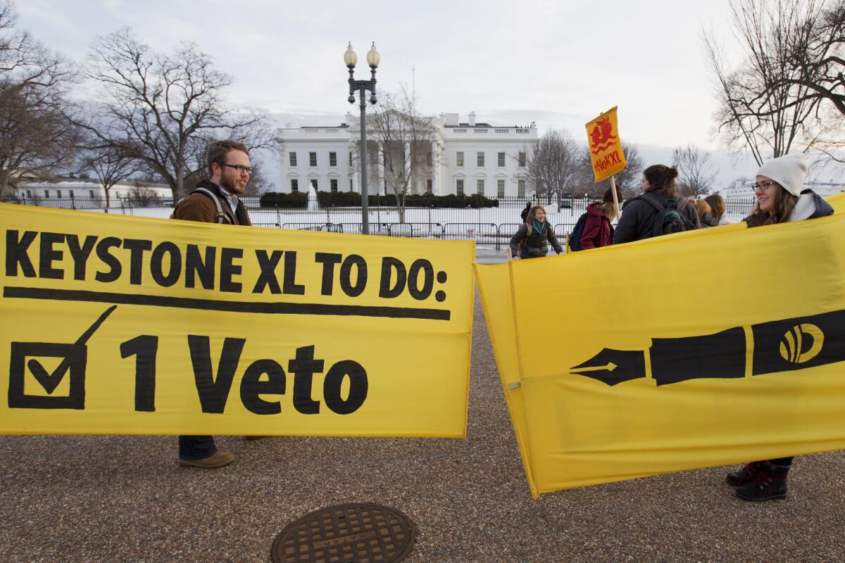 Danny Ruthenberg-Marshall and Lindsey Halvorson leave a demonstration outside the White House supporting President Obama's veto of a bill to approve the Keystone XL pipeline project.