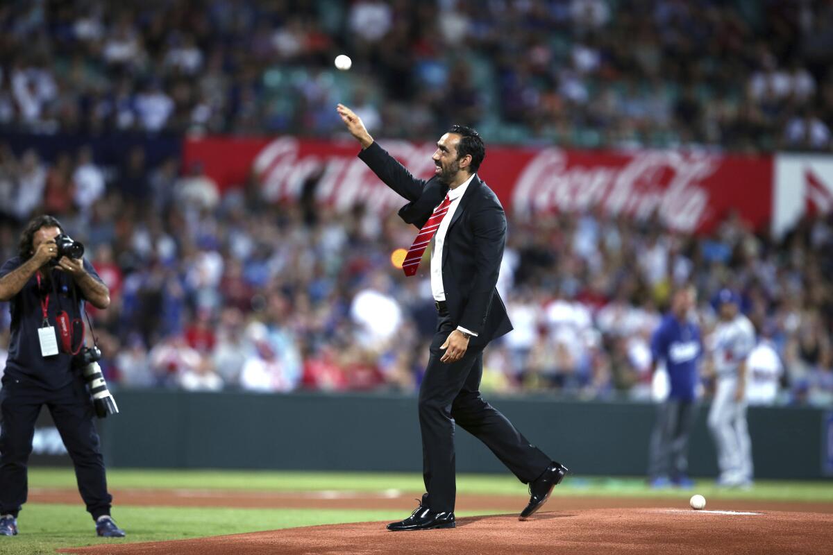 FILE - In this March 22, 2014, file photo, Australian of the year Australian Football League player Adam Goodes throws out the ceremonial first pitch before the Major League Baseball opening game Between the Los Angeles Dodgers and Arizona Diamondbacks at the Sydney Cricket ground in Sydney. Goodes has declined an offer to be inducted into the Melbourne-based AFL's Hall of Fame. (AP Photo/Rick Rycroft, File)
