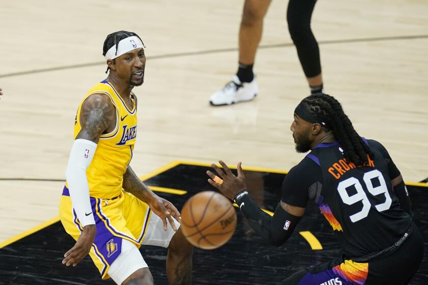 Los Angeles Lakers guard Kentavious Caldwell-Pope, left, gets off a pass sending the ball past Phoenix Suns forward Jae Crowder (99) during the first half of Game 2 of their NBA basketball first-round playoff series Tuesday, May 25, 2021, in Phoenix. (AP Photo/Ross D. Franklin)