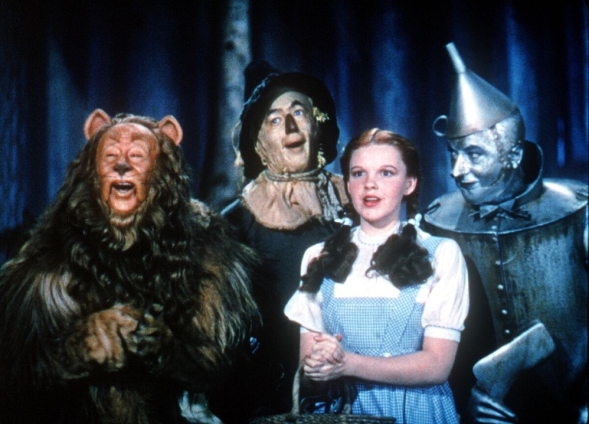 The Cowardly Lion, the Scarecrow, Dorothy and the Tin Woodman in the movie “The Wizard of Oz.”