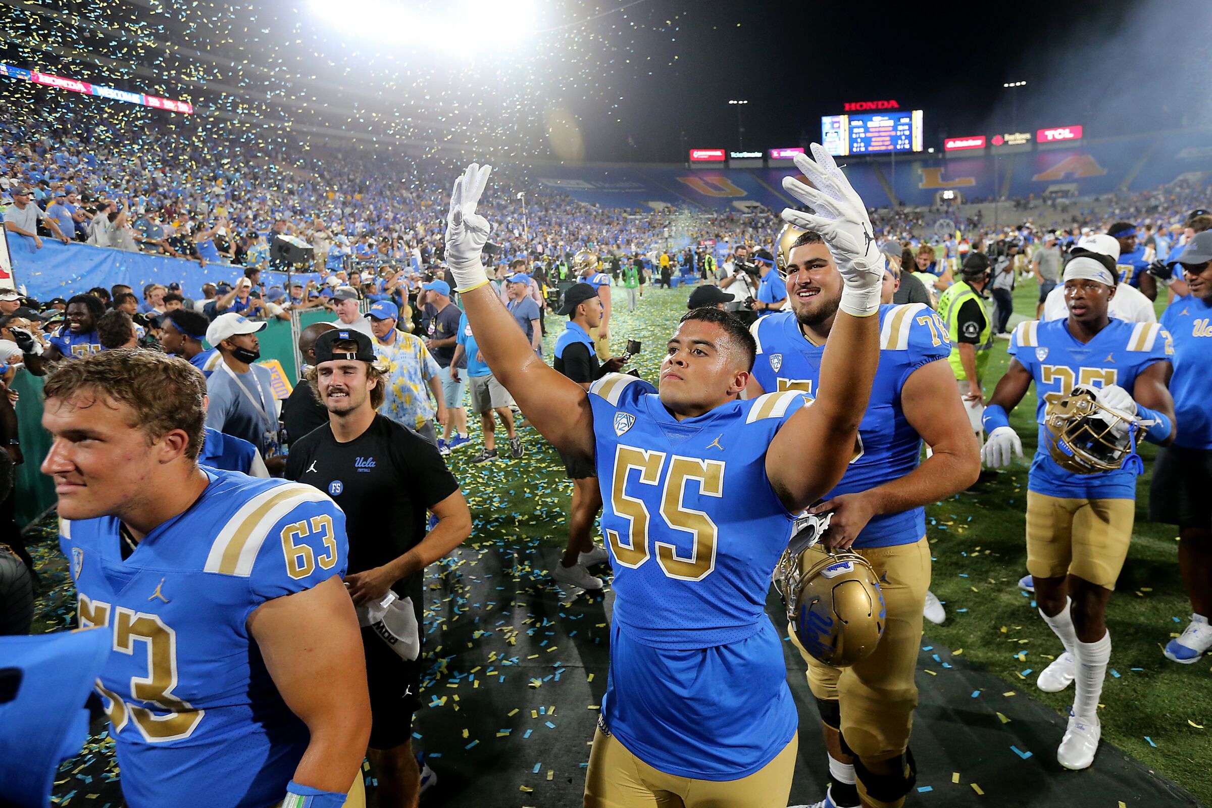 UCLA defensive lineman Tyler Kiehne holds up his hands while walking off the field.