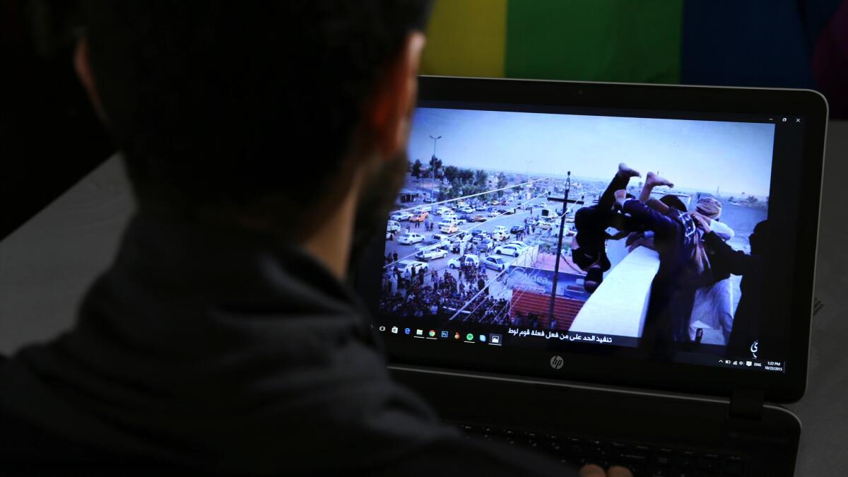 In this Oct. 22, 2015, file photo, Daniel Halaby, a gay Syrian living in southern Turkey, shows a photo from his laptop of Islamic State group militants throwing a man off a roof for allegedly violating the extremists' ban on homosexuality.