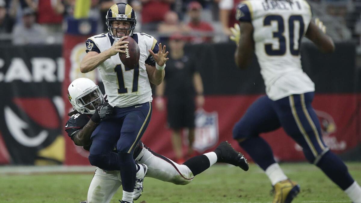 Rams quarterback Case Keenum looks to pass to running back Todd Gurley as he is harassed by Cardinals linebacker Markus Golden during second-half action.